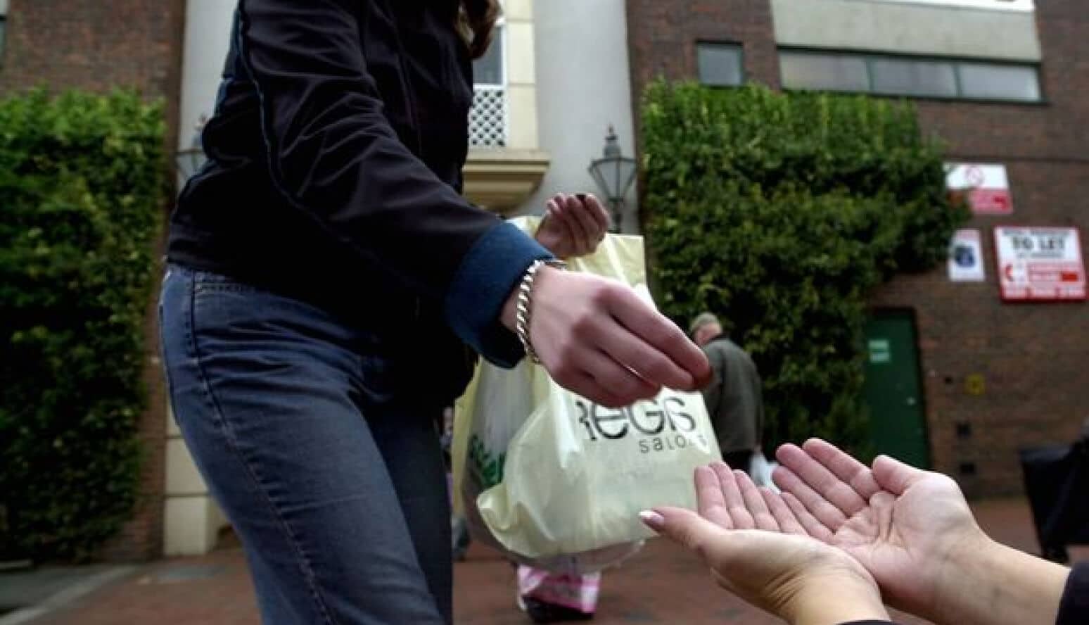 A person giving money to a homeless person